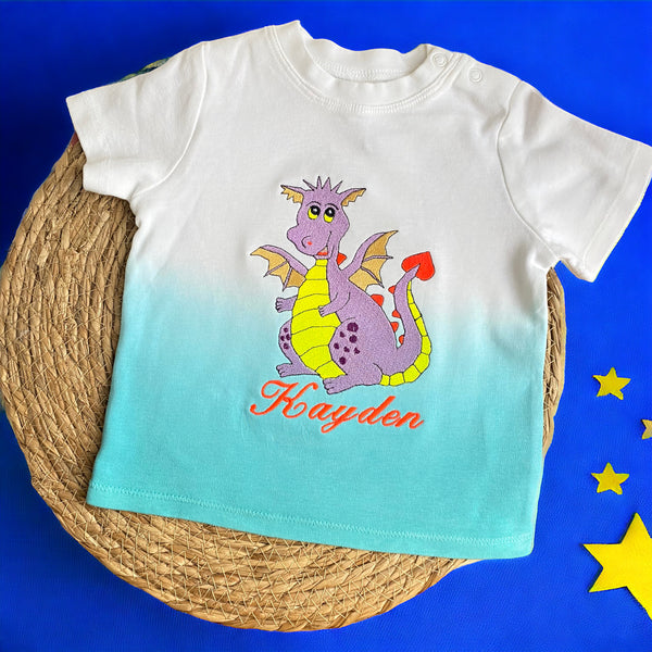 Gepersonaliseerd en geborduurd babyshirt met een lieve paarse draak. Het tye dye shirt is verkrijgbaar in roze wit en blauw wit. Een leuk kraamcadeau als u geen rompertje cadeau wilt doen. De naam wordt onder de draak geborduurd.