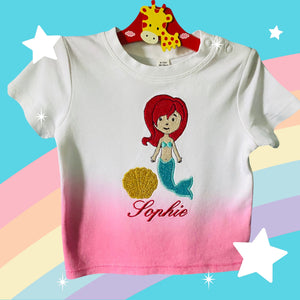 Gepersonaliseerd en geborduurd babyshirt met een lieve zeemeermin met schelp. Het tye dye shirt is verkrijgbaar in roze wit en blauw wit. Een leuk kraamcadeau als u geen rompertje cadeau wilt doen. De naam wordt onder de zeemeermin geborduurd.