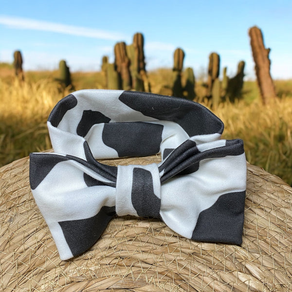 Baby hoofdband met strik in koeprint. Leuk om te geven als kraamcadeau in combinatie met het baby broekje en/of korte broekje of rokje in dezelfde koeprint en het gepersonaliseerde rompertje met geborduurde koe
