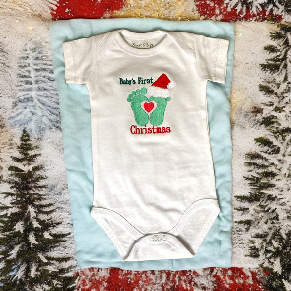 Baby  kerst rompertje met 2 geborduurde voetjes met een kerst muts op en de tekst baby's first Christmas. Een origineel kerst cadeau of kraamcadeau als de baby rond kerst geboren is. 