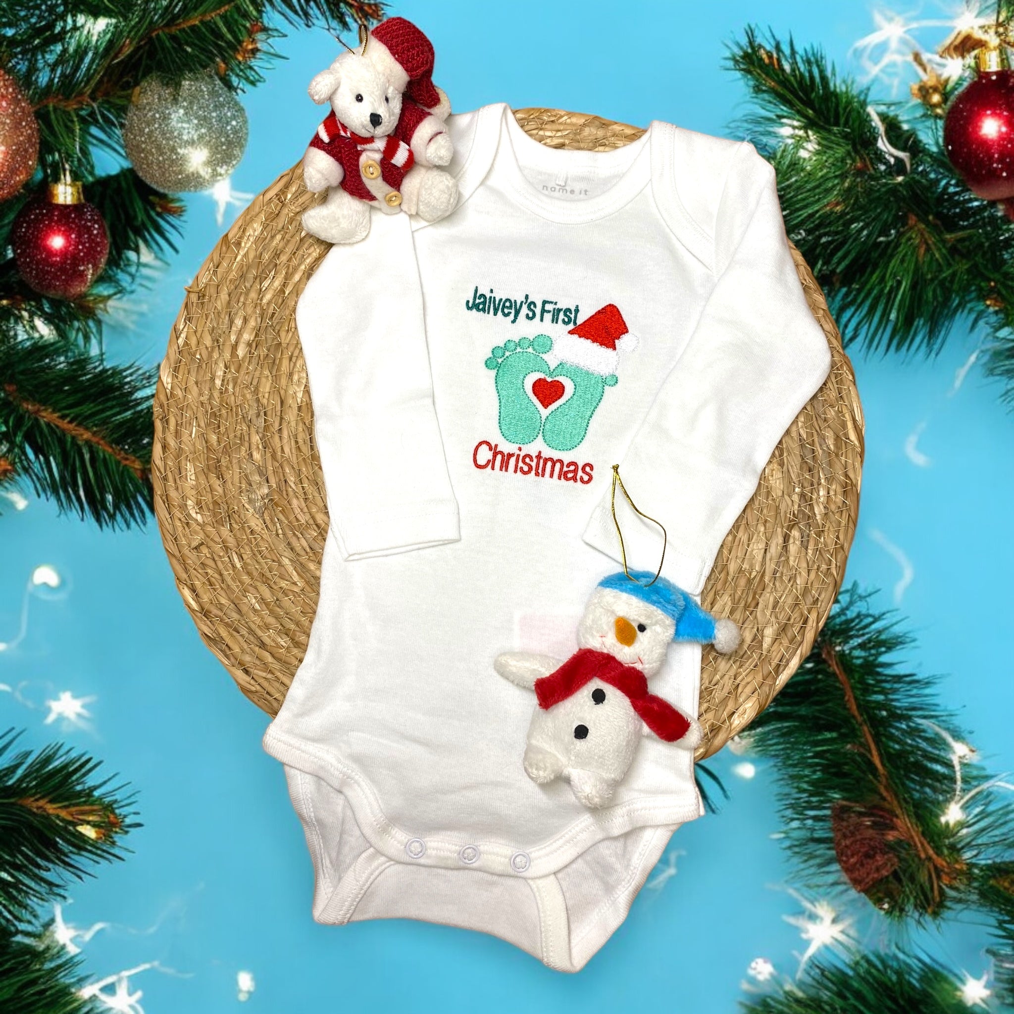 Gepersonaliseerd rompertje voor baby's eerste kerst, met de mogelijkheid om de naam van de baby, zoals 'Liam's First Christmas', te borduren. Het rompertje heeft een enveloppehals en is gemaakt van 100% katoen. Beschikbaar in verschillende uitvoeringen voor een comfortabel en praktisch kerstcadeau