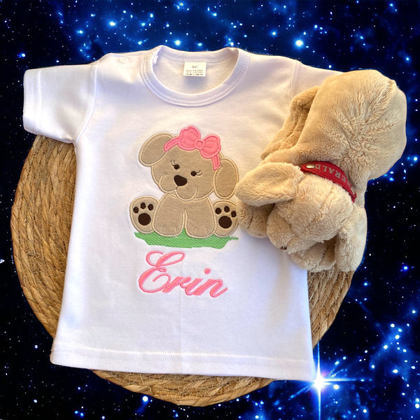 Een gepersonaliseerd meisjesshirt met geborduurd hondje. Het hondje is door  applicatie met Nicky Velours aangebracht en daardoor lekker zacht. De naam wordt in roze onder het hondje geborduurd. De shirts zijn verkrijgbaar in wit en zwart in de maten 56 tm 152.