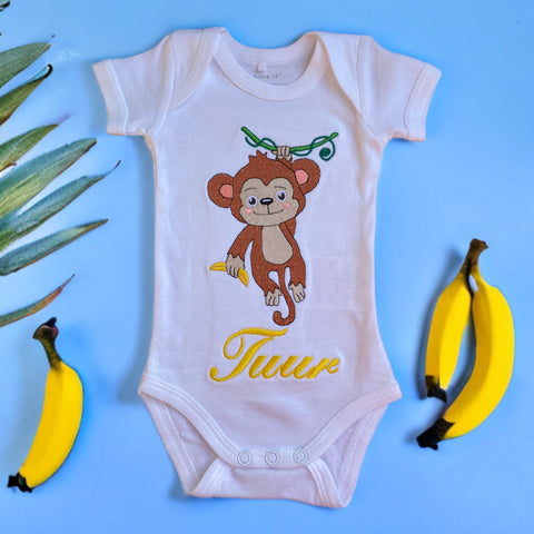 Een gepersonaliseerd rompertje met geborduurde aap met gele banaan en baby naam in geel. Echt een leuk persoonlijk kraamcadeautje. De rompertjes van SaZu Designs zijn verkrijgbaar in wit en zwart, met lange en korte mouw, in de maten 50 tm 68.