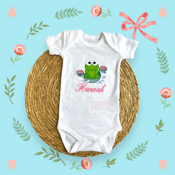 Gepersonaliseerd baby rompertje met geborduurde groene kikker. Een origineel kraamcadeautje. Ook leuk in combinatie met de handgemaakte gepersonaliseerde badcape met kikker.