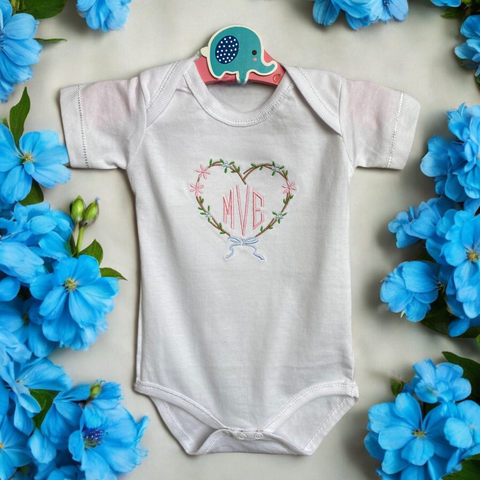 Gepersonaliseerd baby rompertje met geborduurd hart. Een origineel kraamcadeautje door de initialen van de baby in het hart op de romper te borduren. ook leuk in combinatie met een van onze cadeausets.