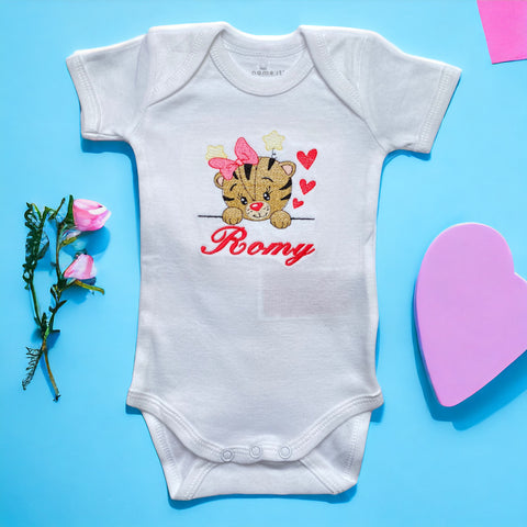 Een gepersonaliseerd rompertje met geborduurde tijgerkop met roze strik en baby naam in hard roze. Echt een leuk persoonlijk kraamcadeautje. De rompertjes van SaZu Designs zijn verkrijgbaar in wit en zwart, met lange en korte mouw, in de maten 50 tm 68.