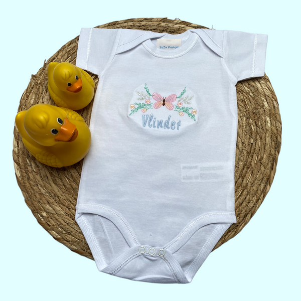 Een gepersonaliseerd rompertje met geborduurde roze vlinder. Onder de vlinder wordt de naam van de baby geborduurd. Echt een leuk persoonlijk kraamcadeautje. De rompertjes zijn verkrijgbaar in de maten 50 tm 68.