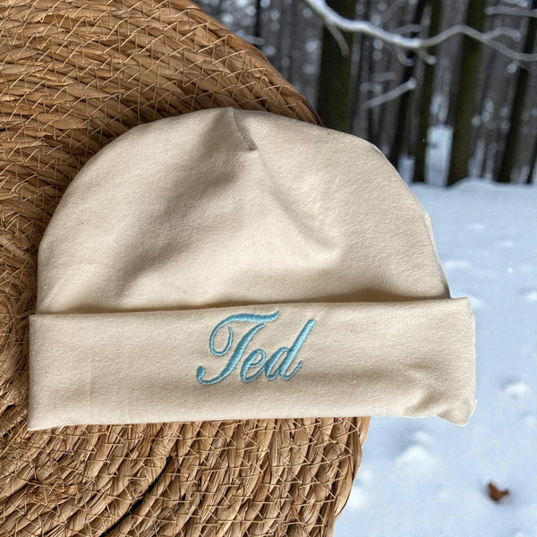 Leuk kraamcadeautje: een handgemaakt baby mutsje in gebroken wit met geborduurde baby naam in divers kleuren. Bijpassend is een handgemaakt gepersonaliseerd baby broekje en handgemaakte baby sokjes verkrijgbaar waarmee u een leuke set cadeau kan doen