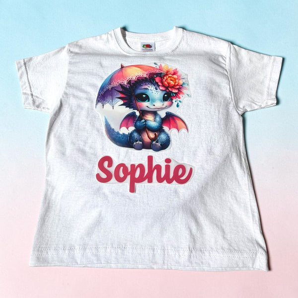 Gepersonaliseerd kinder T-shirt met illustratie van een draakje met kleurrijke parasol. Ontworpen en bedrukt door SaZuDesigns.