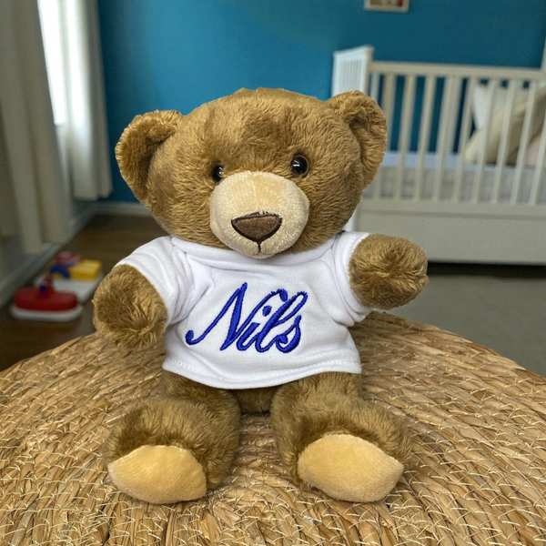 Deze donker bruine beer met creme kleur neus en voetzolen is een super leuk kraamcadeau. Het beertje is maar 15 cm hoog. De geboorteknuffel krijgt een shirtje aan. Op dit shirtje wordt de naam en indien gewenst de geboortedatum van de baby geborduurd