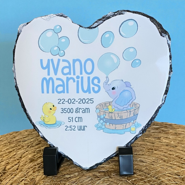 Keramiek tegeltje met de naam en geboortegegevens van de baby en voorzien van een badderend olifantje. De naam en de oren van de olifant worden bedrukt  in roze of blauw. De tegel van 15 cm * 15 cm is ook verkrijgbaar in leisteen of een leisteen hart