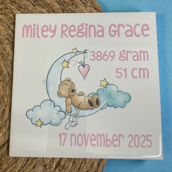 Uniek Kraamcadeautje, bedrukte geboortetegel met naam en geboorte gegevens van de baby met een plaatje van een beertje liggend op de maan. De tekst is of in groen of in roze bedrukt.