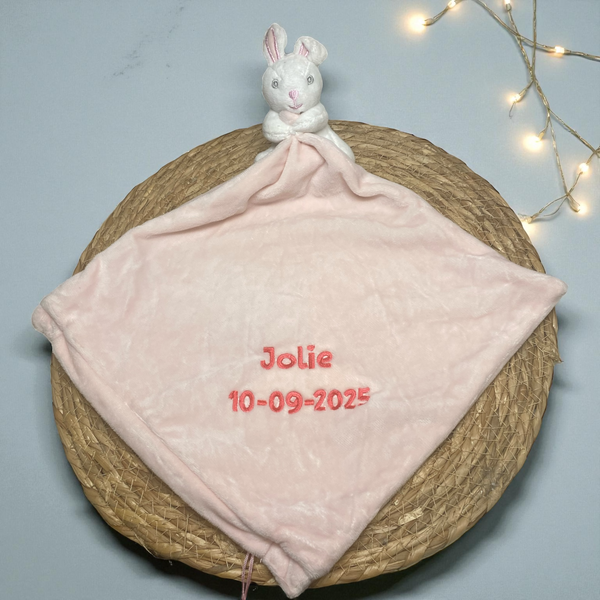 Lief pluche konijntje met een gepersonaliseerde roze deken, geborduurd met naam en geboortedatum – perfect kraamcadeau