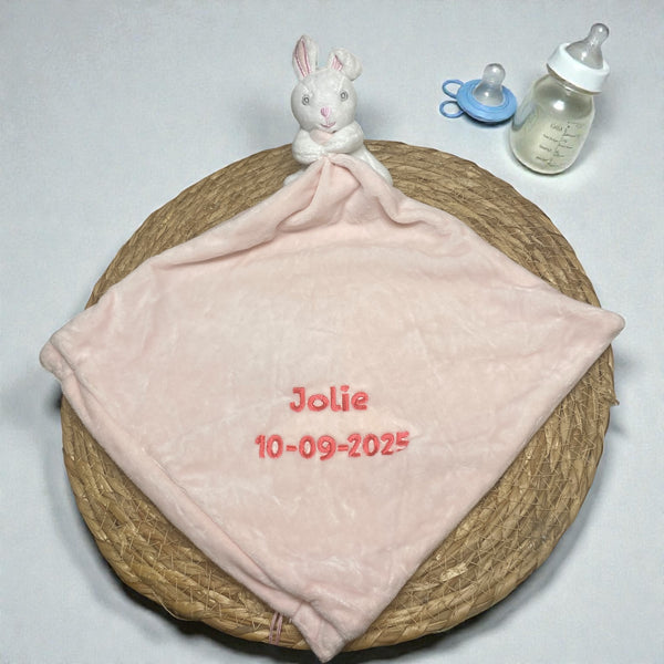 Lief pluche konijntje met een gepersonaliseerde roze deken, geborduurd met naam en geboortedatum – perfect kraamcadeau