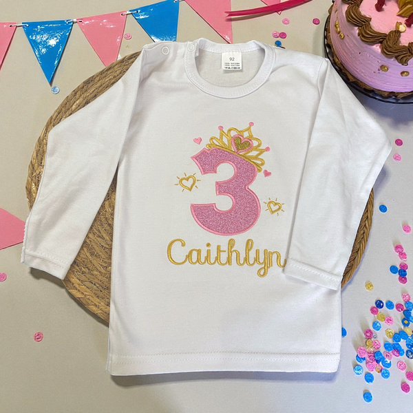 Verjaardagsshirt met roze glitter cijfer, gouden kroon en naam, ideaal voor een prinsessenfeestje.