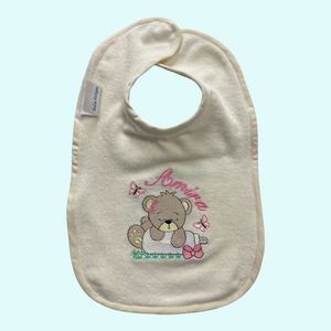 Handgemaakt slabbetje met geborduurde beer hangend over een baby melkfles. Het slabbetje wordt gepersonaliseerd met de naam van de baby. Een uniek kraamcadeau die niet in de winkel verkrijgbaar is.