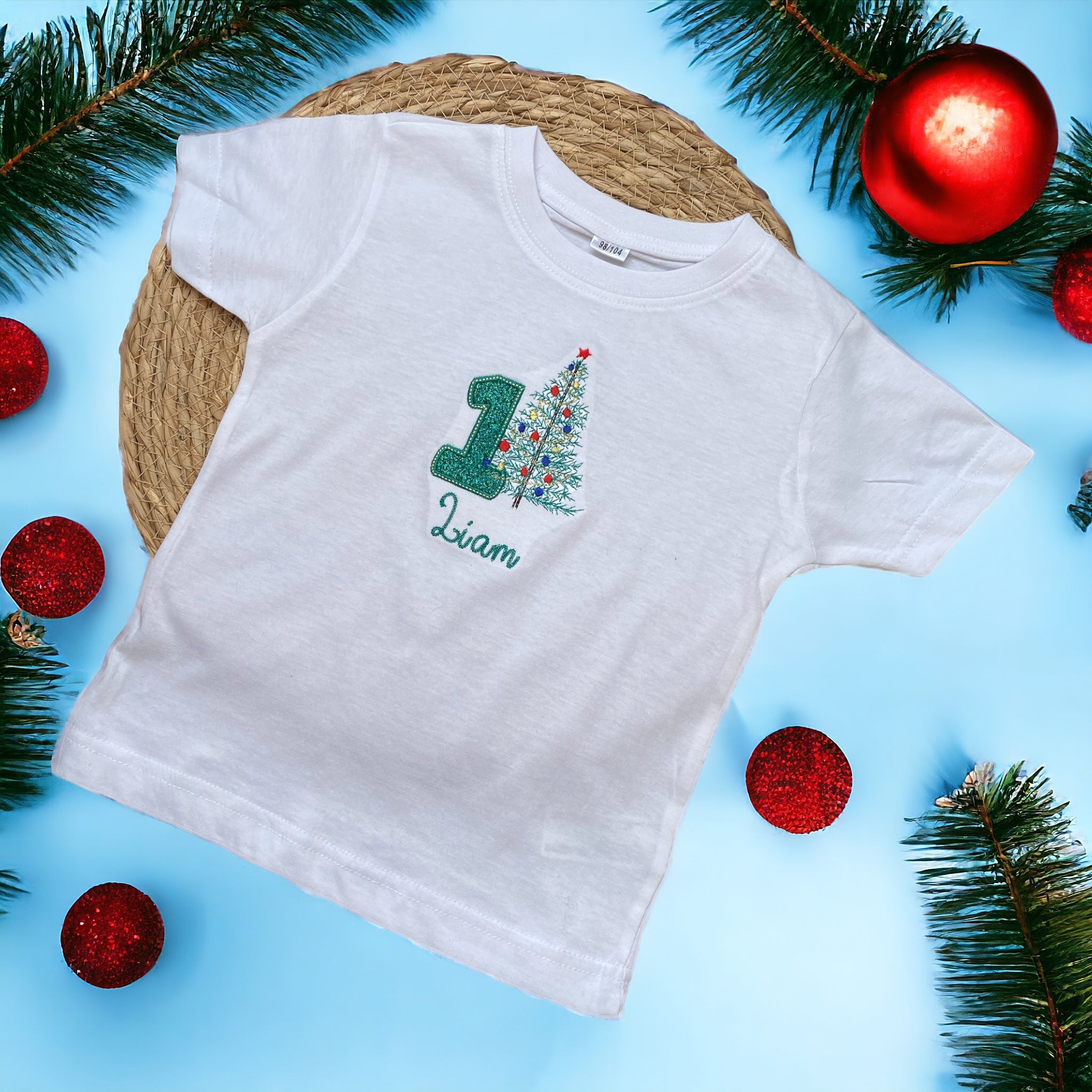 Uw kinds eerste kerstmis, daar hoort een leuk shirt bij. Dit gepersonaliseerde shirt met geborduurde kerstboom en groen glitter cijfer 1 is het perfecte eerste kerstmis shirt voor uw zoon of dochter.