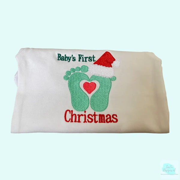 Geborduurde baby romper voor de kerstdagen. Voorzien van 2 baby voetjes met een kerstmuts en de tekst :baby's first Christmas"