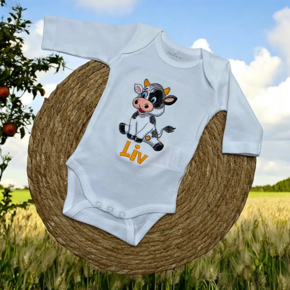 Baby rompertje met geborduurde koe en naam van de baby. In een set met het broekje of de geboorteknuffel koe een super leuk kraamcadeautje. De rompertjes van SaZuDesigns zijn verkrijgbaar in wit en zwart in de maten 50 tm 68.