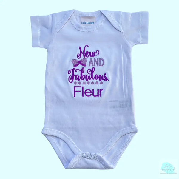 Een geborduurde romper met de tekst " new and fabulous", wordt tevens gepersonaliseerd. Tekst in paars en lila. Een uniek kraamcadeau voor een nieuwe en fabuleuze baby. Romper is 100% katoen.