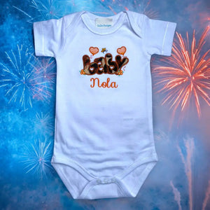 Dit rompertje is een uniek kraamcadeautje. De tekst baby wordt met een giraffen print stof op het rompertje geborduurd en de naam van de baby wordt daaronder in het oranje geborduurd. Uniek omdat deze print niet in de winkel verkrijgbaar is.